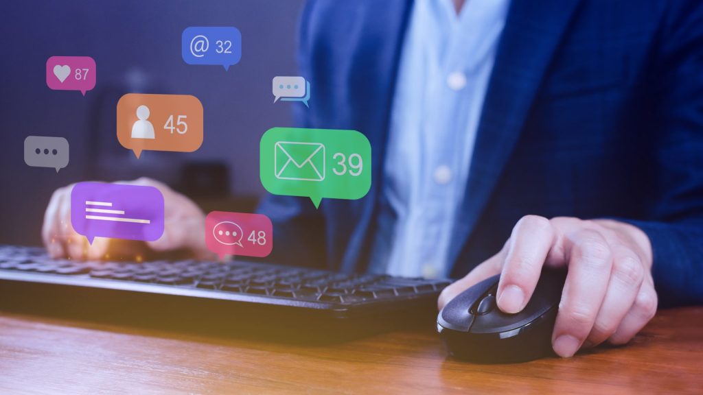 People using social media and digital online marketing concepts on laptop with icons such as notifications, messages, comments on the smartphone screen.