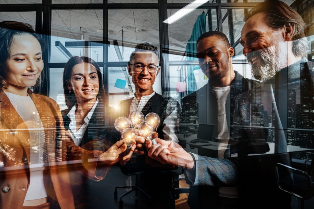 Teamwork and brainstorming concept with businessmen that share an idea with lamps.