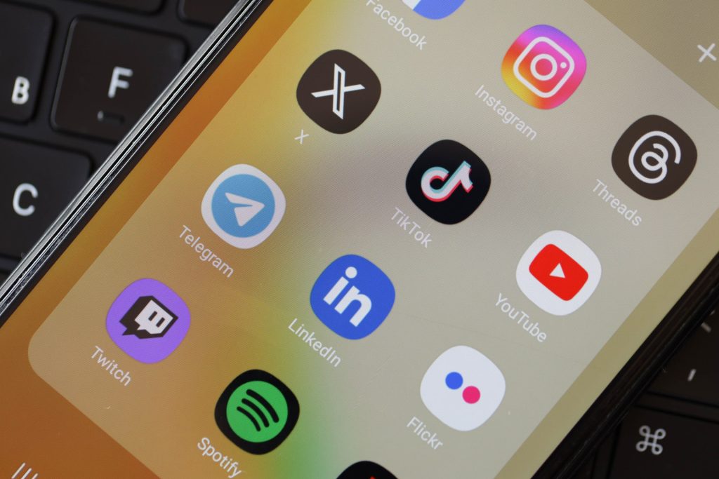 Social Media icons group on Galaxy A04s smartphone display on MacBook keyboard.