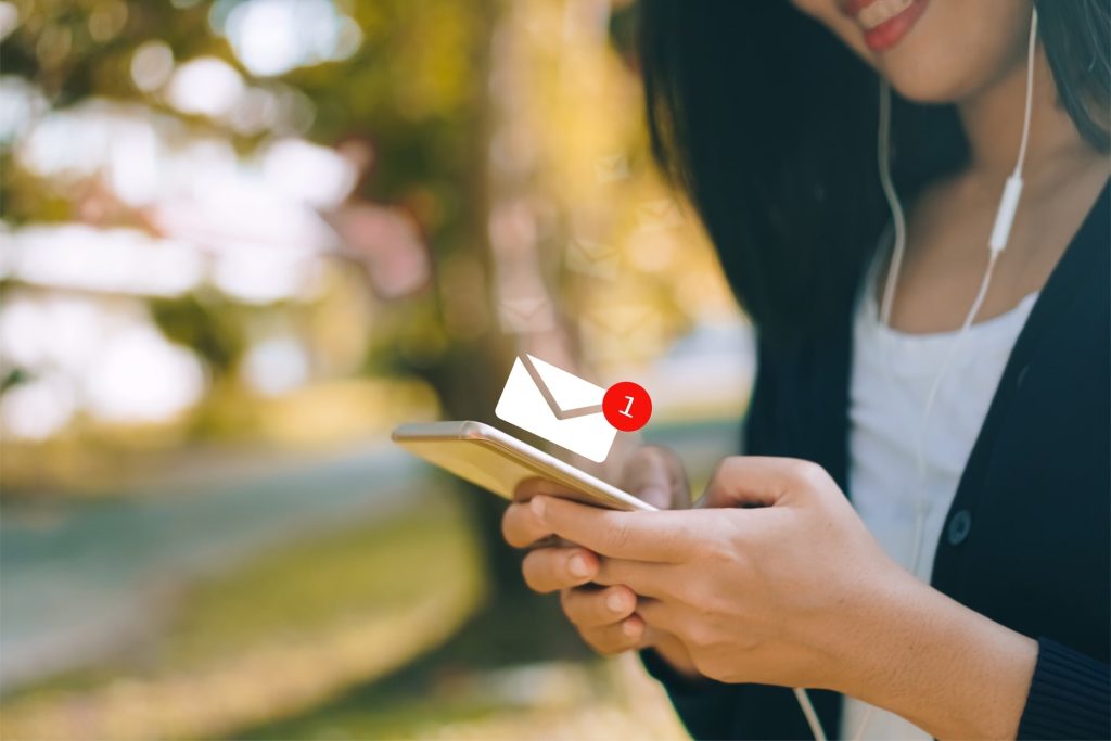 Woman hand using smartphone and it's show 1 email recieve notification icon pop up on screen of mobile phone. Business communication technology concept.