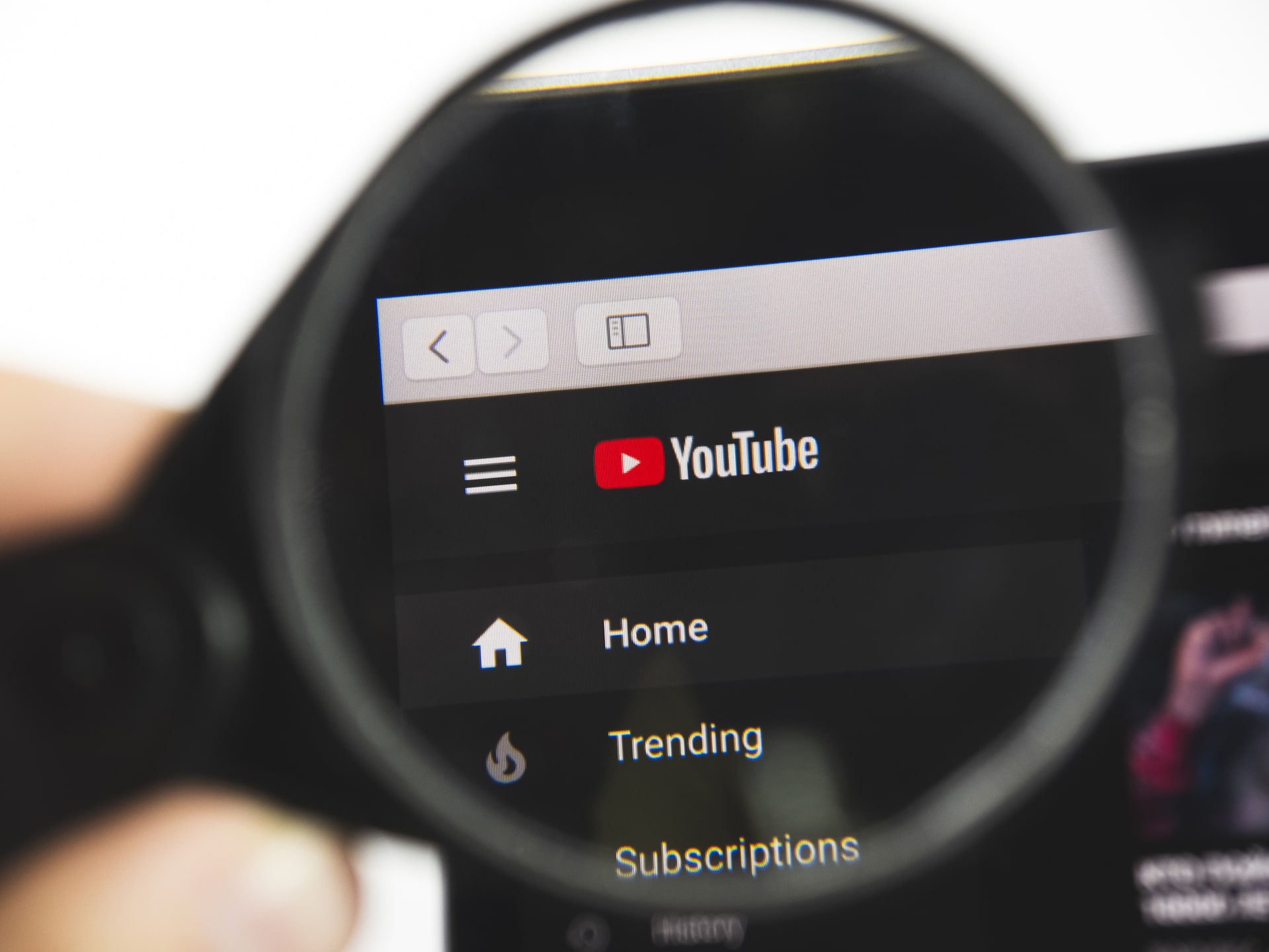 YouTube logo on a web page. View of the monitor screen through a magnifying glass.